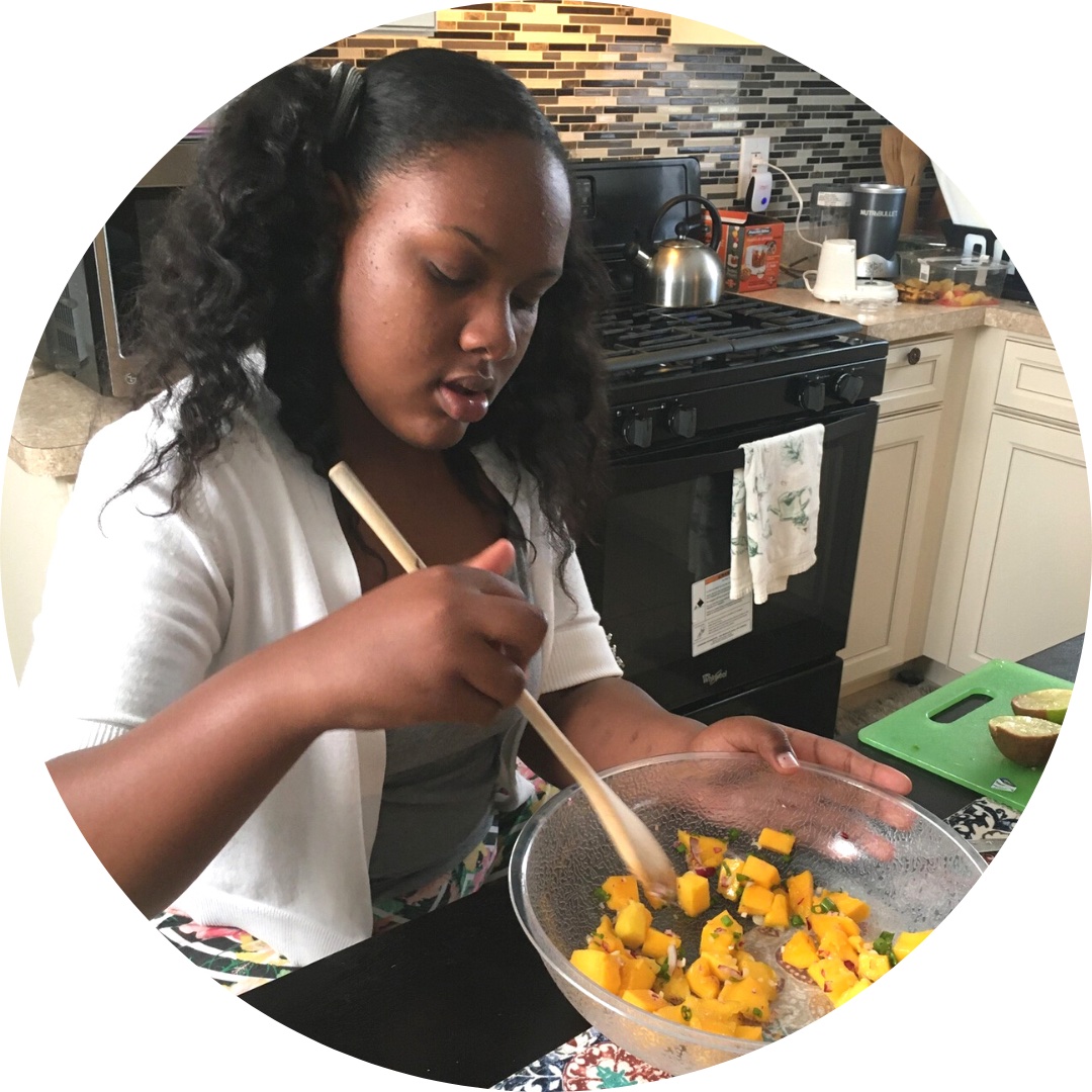 A teen stirs a bowl of yellow vegetables