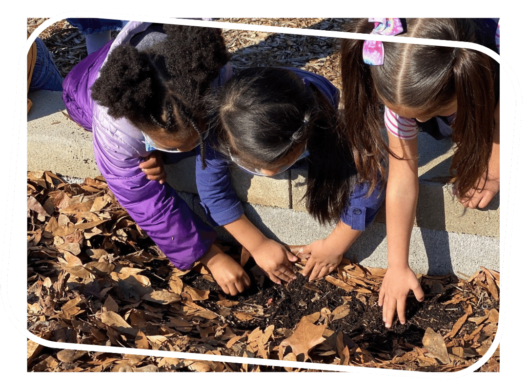 Benefits header Three kids looking through brown leaf mulch in a raised garden bed.