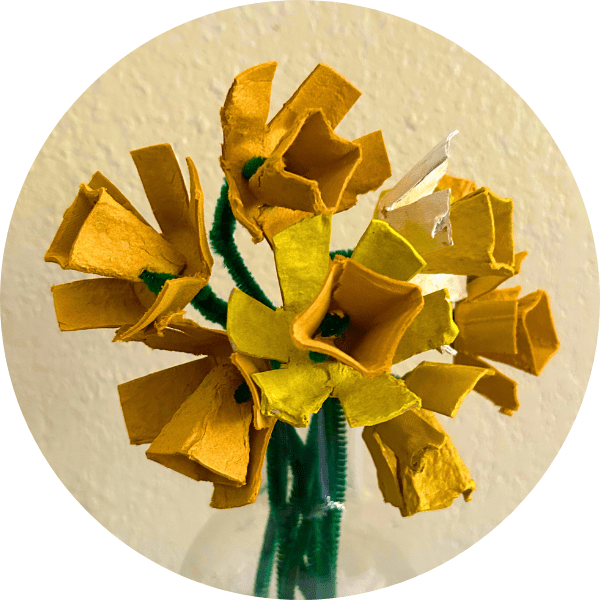 Yellow cardboard daffodil flowers on green stems.
