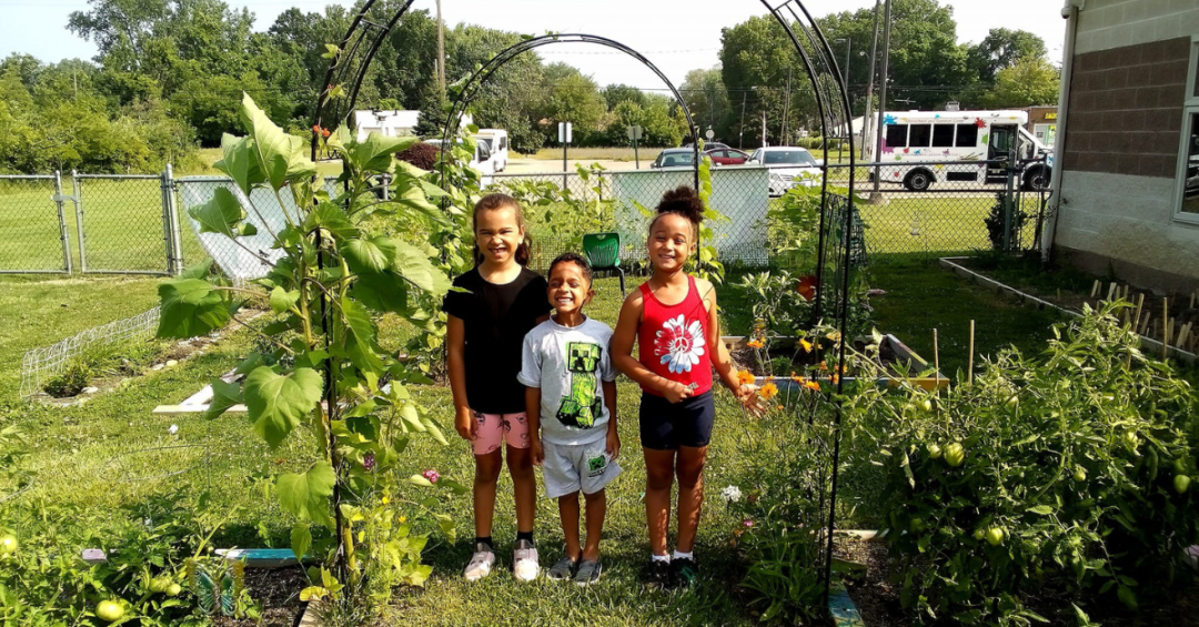 Three kids of different ages in a garden