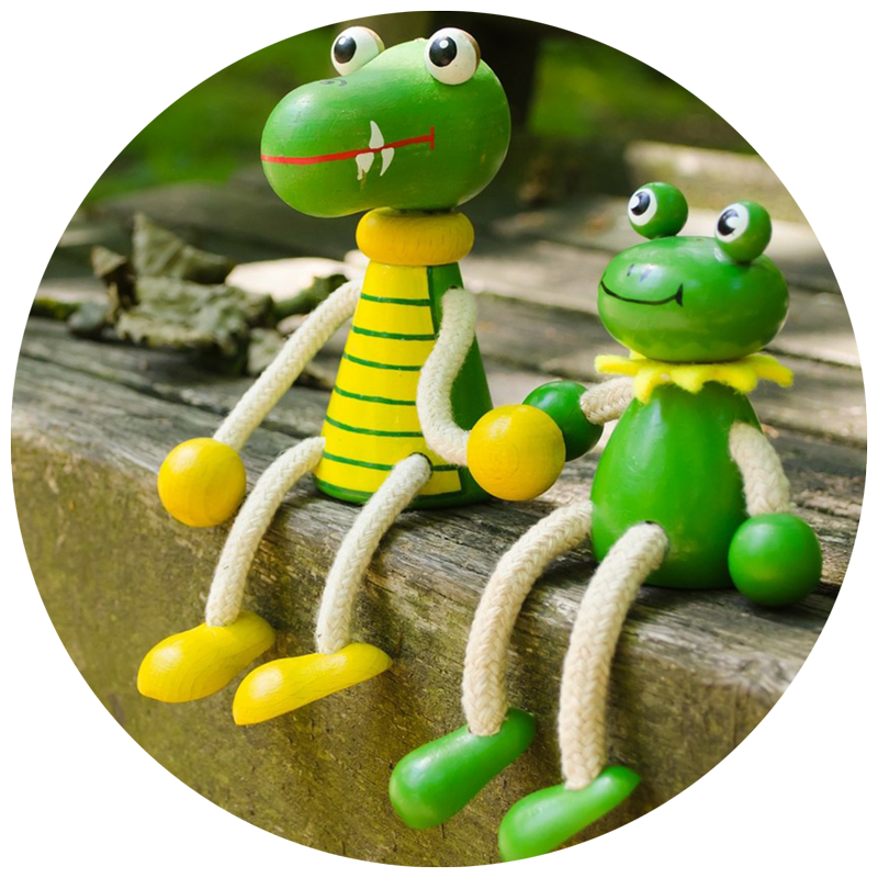 small wooden frog and crocodile figurines sitting in a pirate's garden