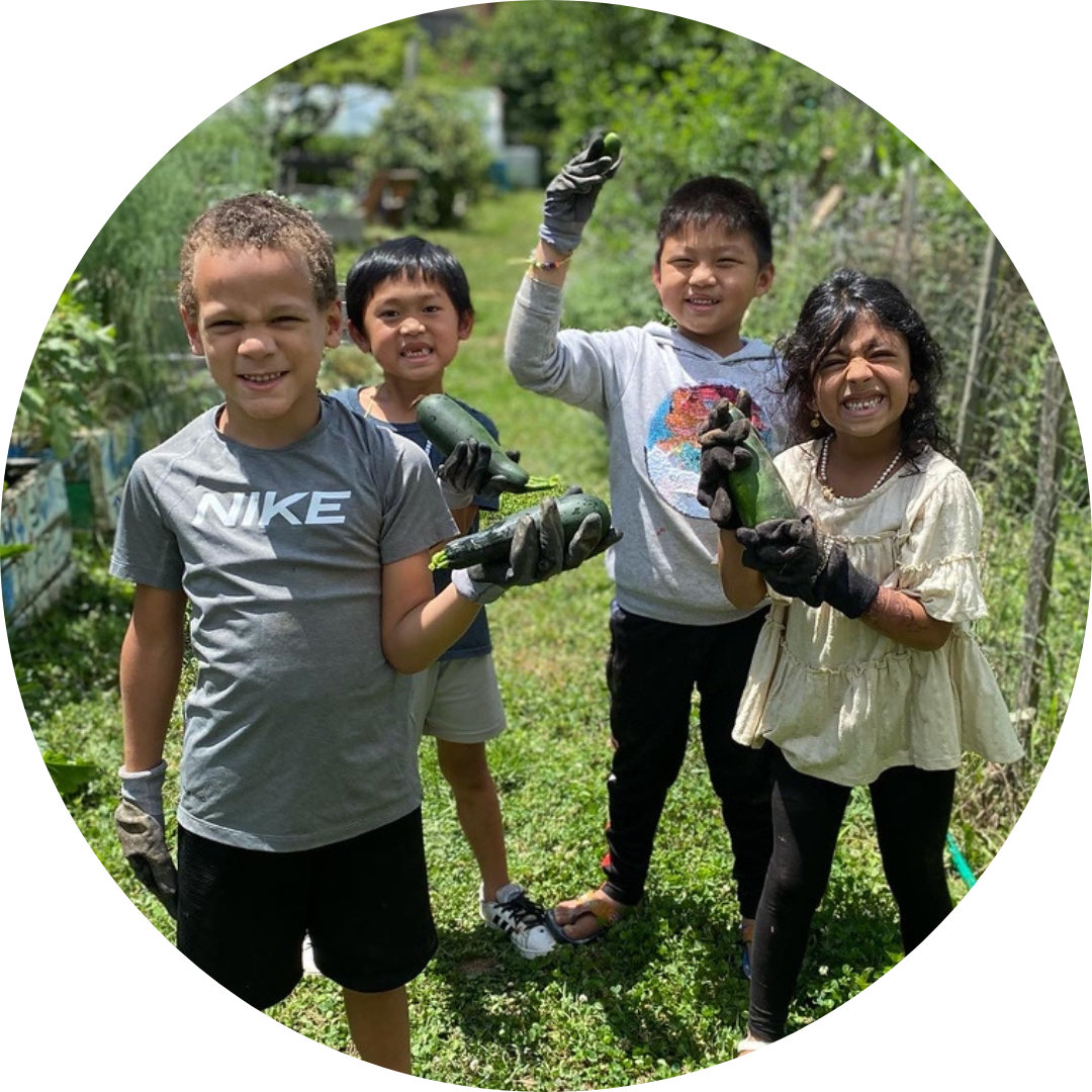 Four kids in a garden, waving at the camera